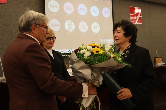 profesor podczas uroczystości, z kwiatami