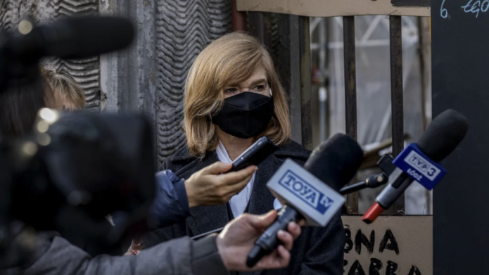 Portret rektor Żądzińskiej w maseczce, na konferencji prasowej, na tle transparentów