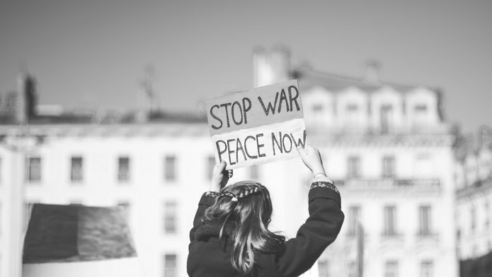 kobieta trzyma baner z napisem Stop war Peace now