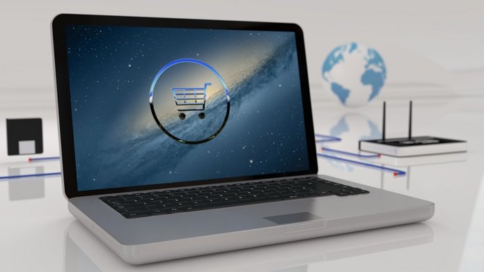 laptop na jasnym tle, na ekranie ikona wózka zakupowego
