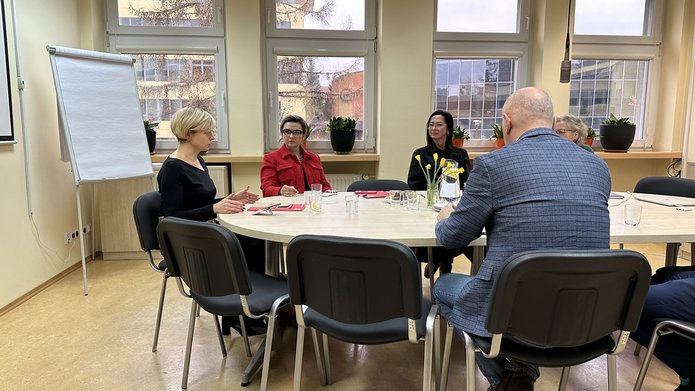 grupa osób siedząca przy okrągłym stole