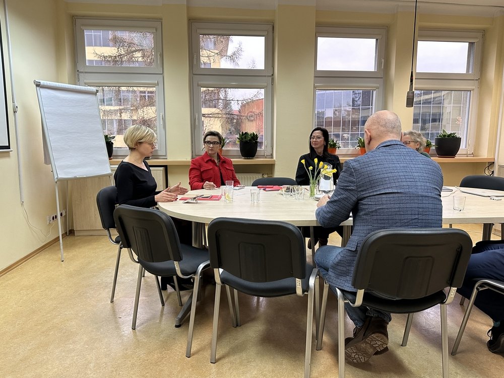 grupa osób siedząca przy okrągłym stole