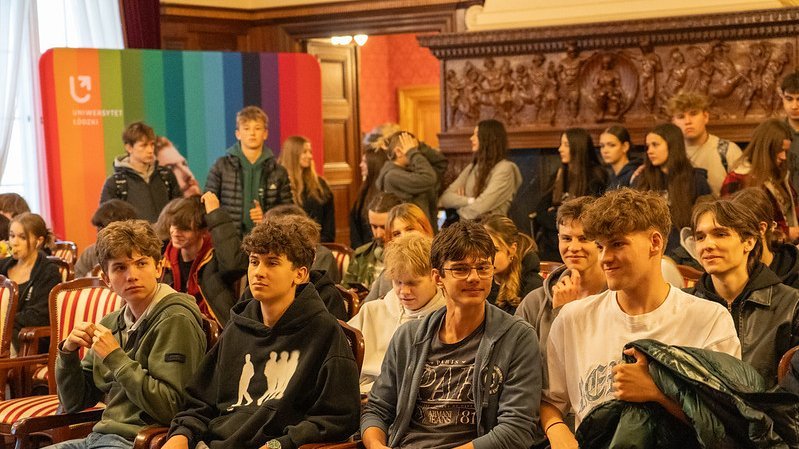 grupa młodych ludzi w sali pałacu