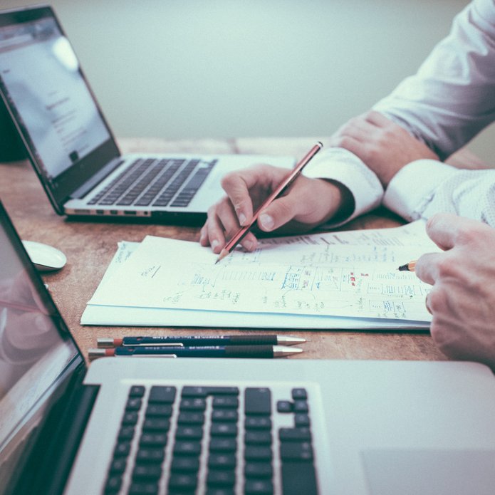 Dwie osoby przy laptopach i notatkach