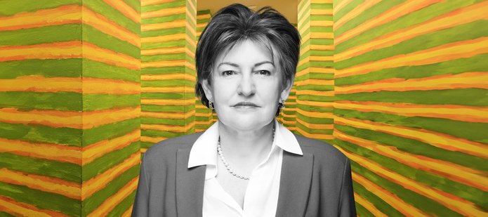 prof. Aneta Pawłowska na tle instalacji malarskiej Leona Tarsewicza. Pracę tę tworzą dwa równoległe rzędy 24 identycznych filarów. Znajdują się one w wąskim, prostym korytarzu, który łączy dwie różne części wystawy. Filary pomalowane są w poziome zielone, żółte i pomarańczowe paski.