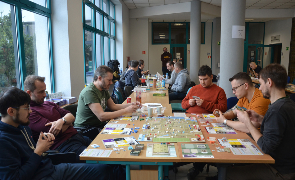 osoby uczestniczące w grze siedzące wokół stołu z grą osoby uczestniczące w grze siedzące wokół stołu z grą