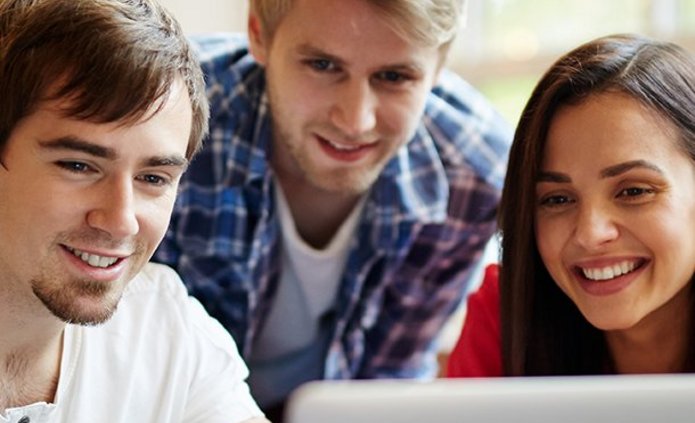 Grupa trójka młodych ludzi, którzy pracują wspólnie przy komputerze