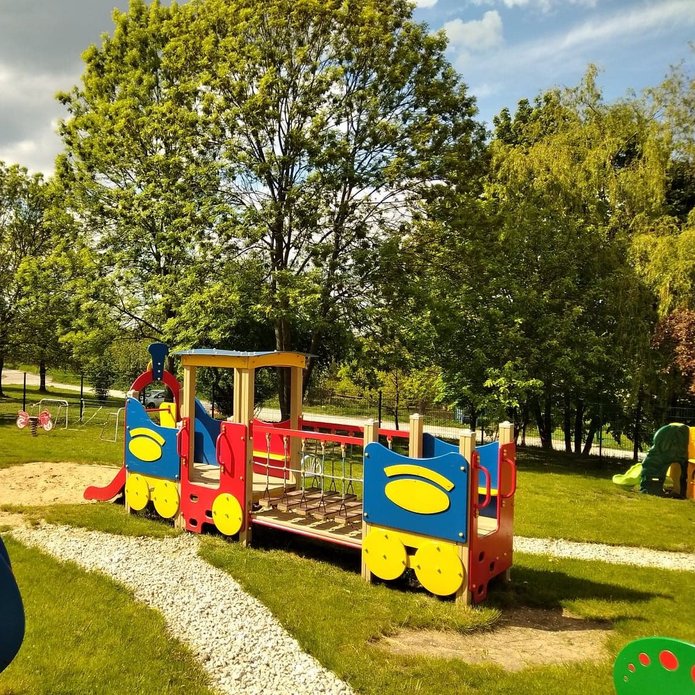 Kolorowa drewniana ciuchcia na placu zabaw dla dzieci