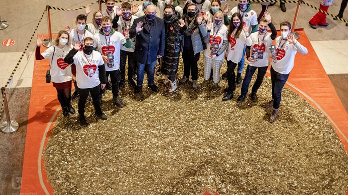 Zdjęcie członków koła naukowego z Rektorem UŁ w manufakturze przy sercu zbudowanym z monet