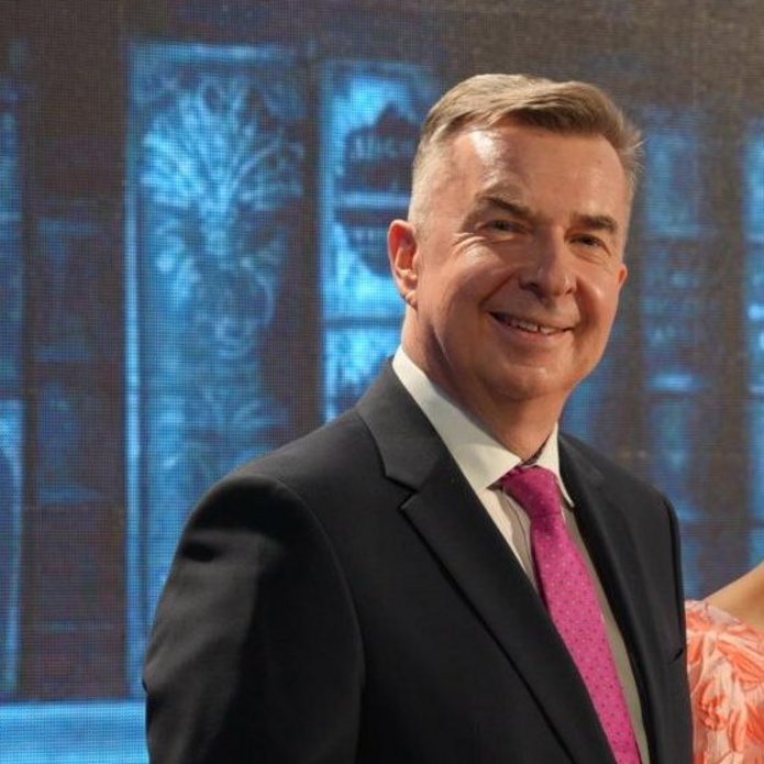 minister nauki stoi na scenie i uśmiecha się do zdjęcia 