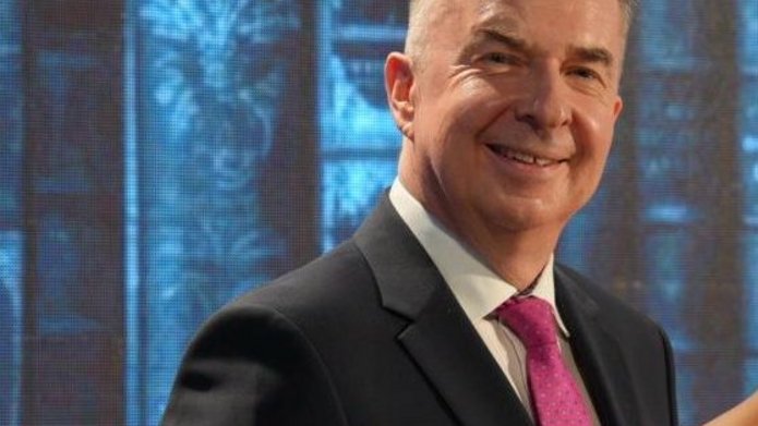 minister nauki stoi na scenie i uśmiecha się do zdjęcia 
