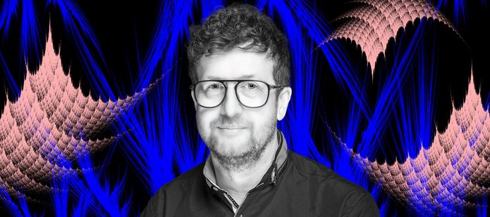 prof. Dariusz Wardowski na kolorowym tle z fraktalami