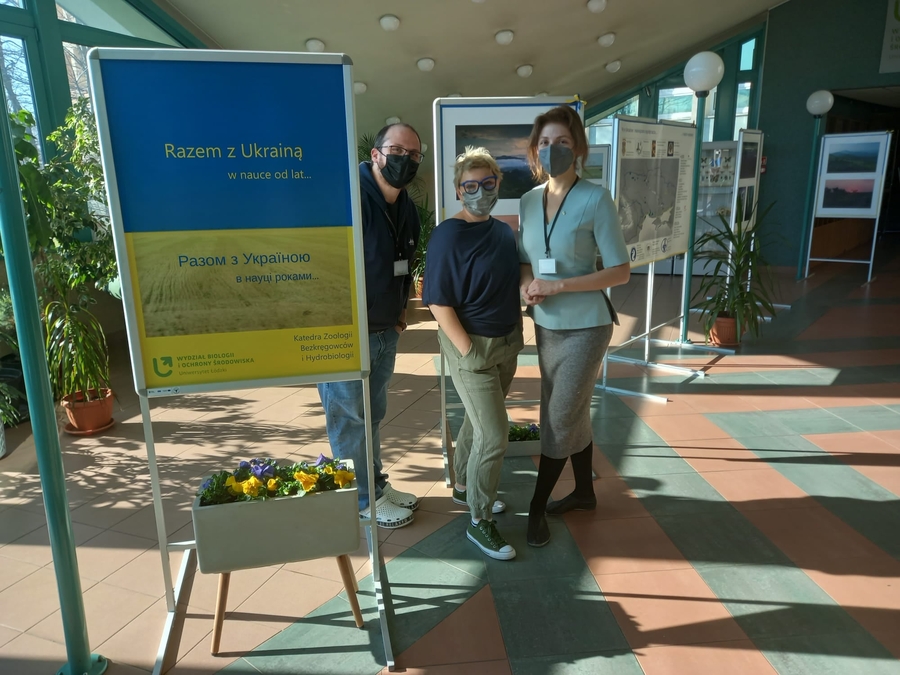 two women and a man wearing protective face masks at a photo exhibition
