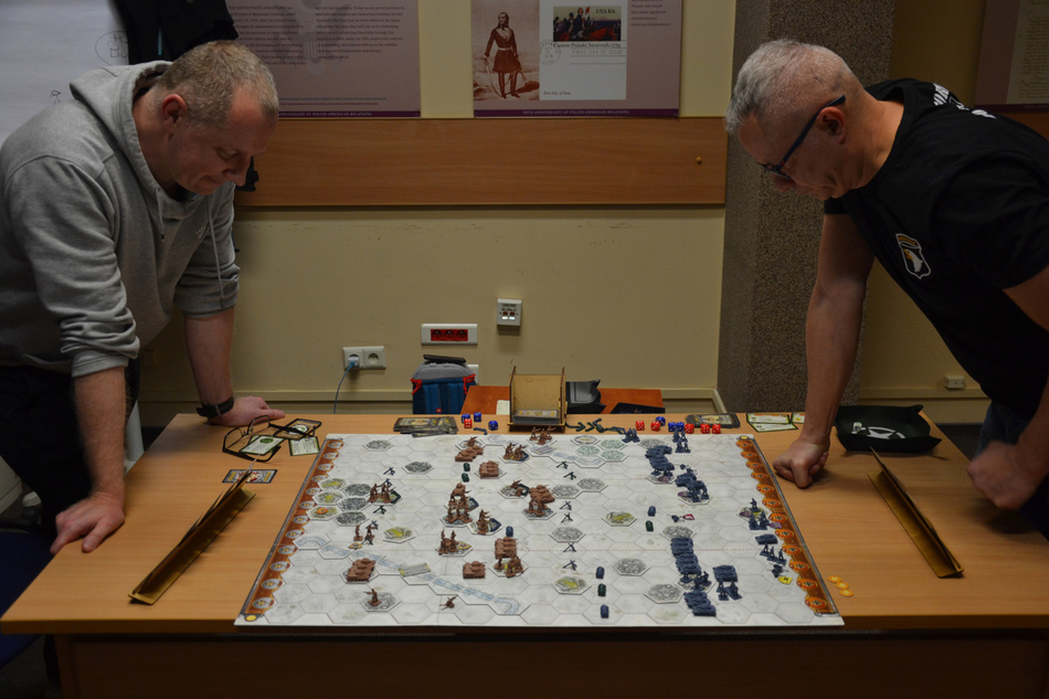 osoby uczestniczące w grze siedzące wokół stołu z grą osoby uczestniczące w grze siedzące wokół stołu z grą