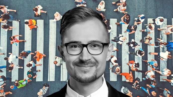Dr Jakub Zasina on a background of a crowded pedestrian crossing seen from a bird's eye view, vertically from above
