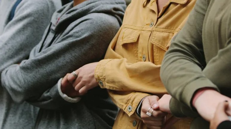 A photo depicting silhouettes of people holding each other's hands