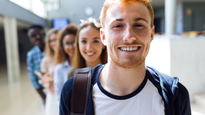 kolorowe zdjęcie przedstawiające grupę uśmiechniętych studentów patrzących prostu w obiektyw