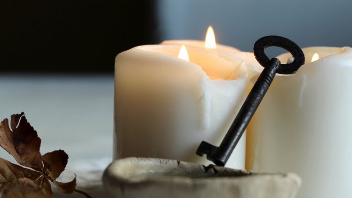 three white candles and a key