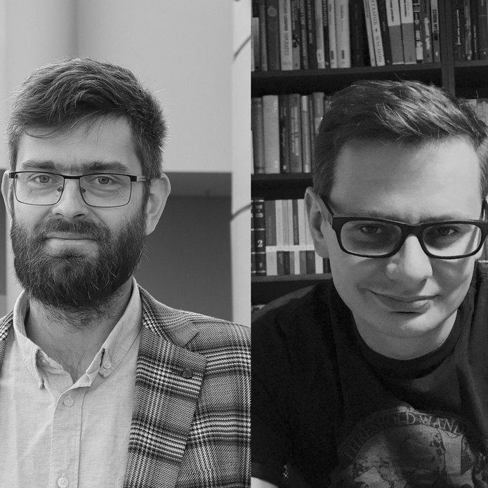 Dwóch mężczyzn w okularach. Jeden w z brodą i w marynarce, drugi w t-shircie.