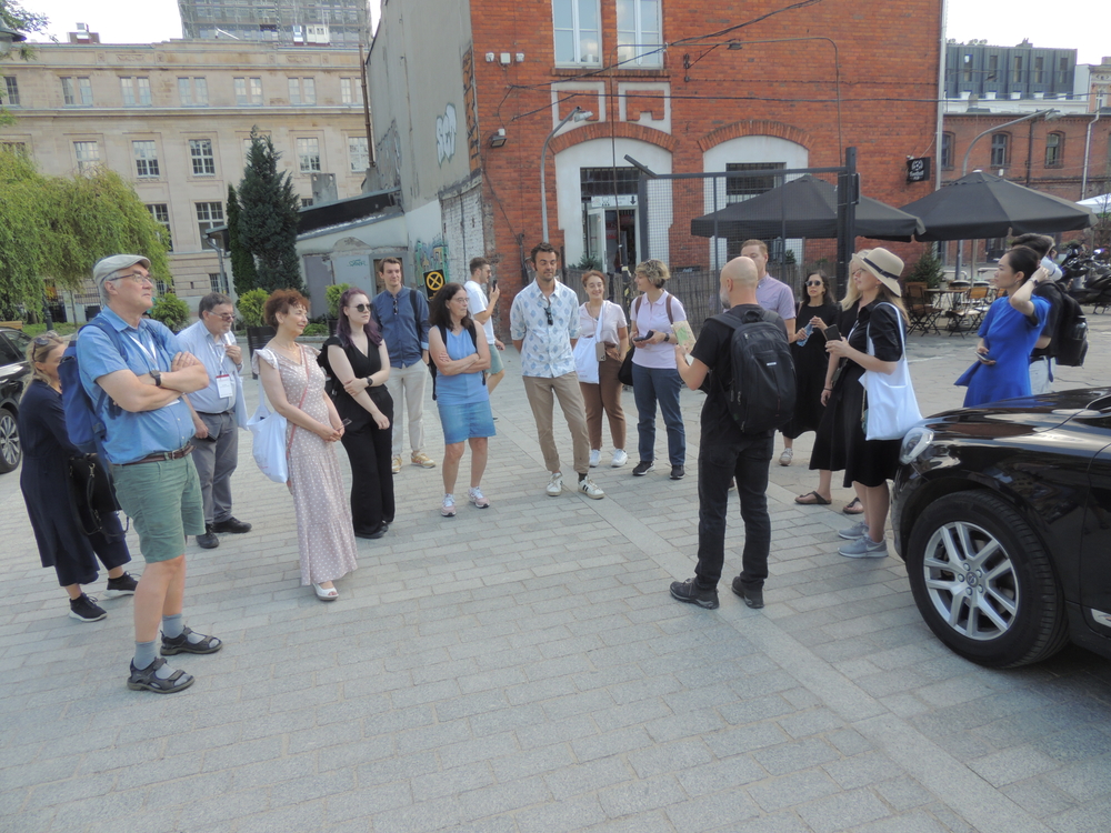 A group of people standing and listening to a city guide
