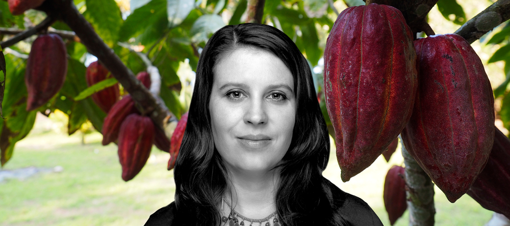 Dr Izabela Stachowicz against the background of cocoa fruit hanging from a branch