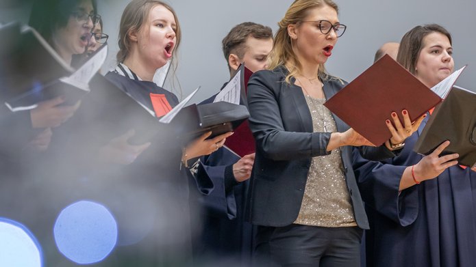 The University of Lodz Choir – women and men singing and holding sheet music 
