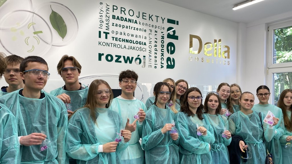 grupa młodych ludzi w ochronnych fartuchach w laboratorium chemicznym
