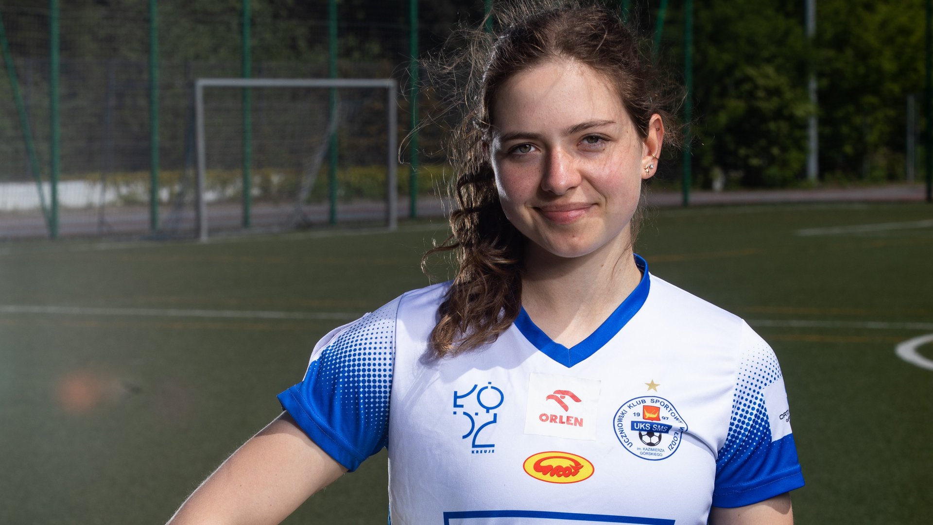 [Translate to English:] Dziewczyna w sportowym stroju z piłką