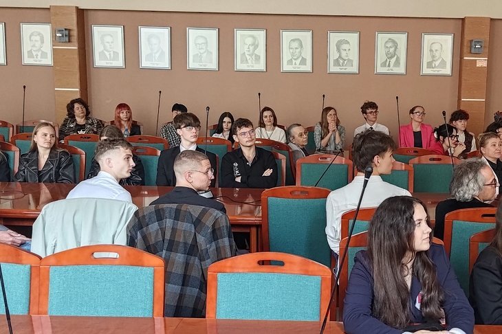 młodzi ludzie siedzą i obserwują z zaciekawieniem 