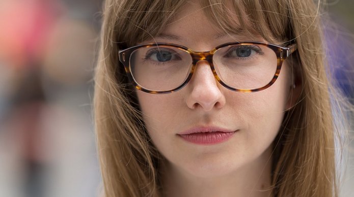 młoda dziewczyna w okularach z delikatnym uśmiechem