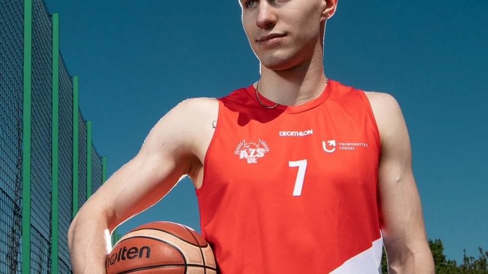 [Translate to English:] Chłopak z piłka na boisku do koszykówki