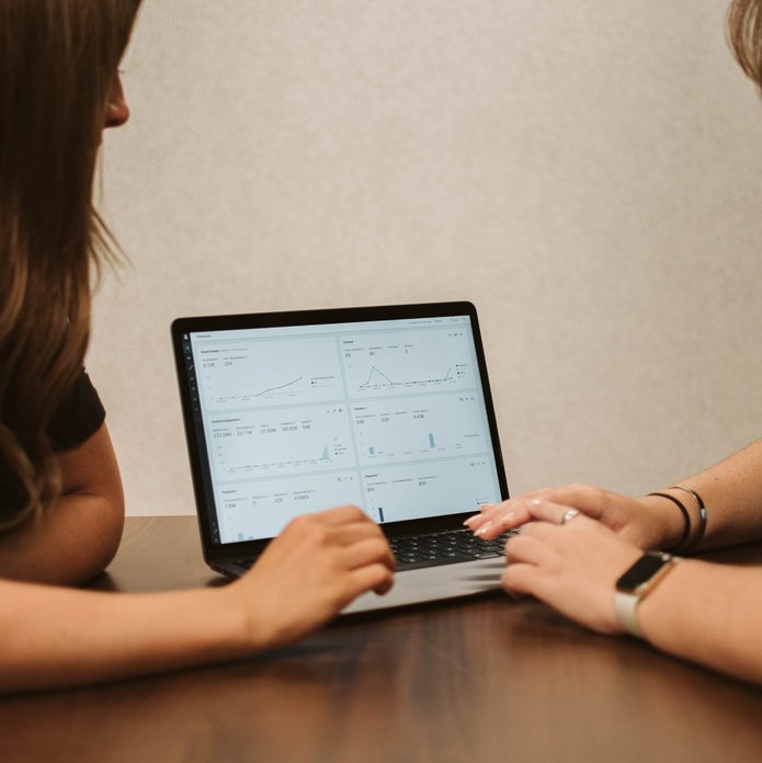 Two ladies checking data on a laptop