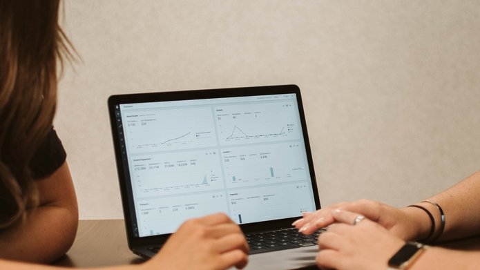 Two ladies checking data on a laptop