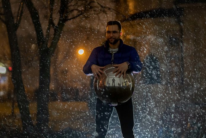Uśmiechnięty chłopak w padającym śniegu