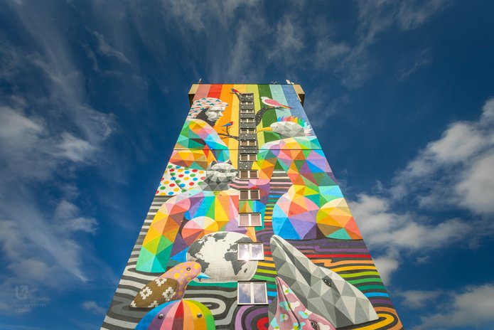 a colourful photo showing a mural of a rainbow on one of the dormitories of the University of Lodz