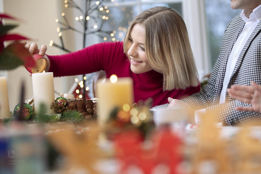 a female student in a red sweater sitting at a Christmas table