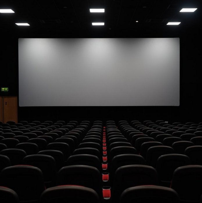 Pusta sala kinowa, ekran i krzesełka. Zdjęcie poglądowe.