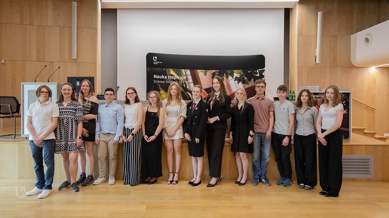A group of young people – winners of the Innovation Laboratory competition – stand in an auditorium posing for a photograph