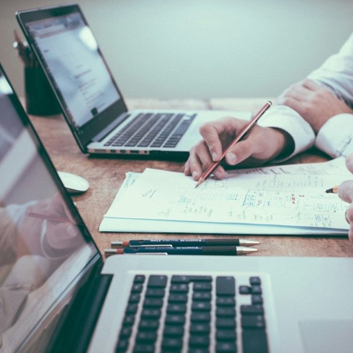 Dwie osoby pracują przy komputerach. Zdjęcie poglądowe.