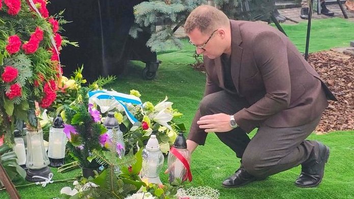 Dr Wojciech Marciniak przed grobem dzieci z obozu