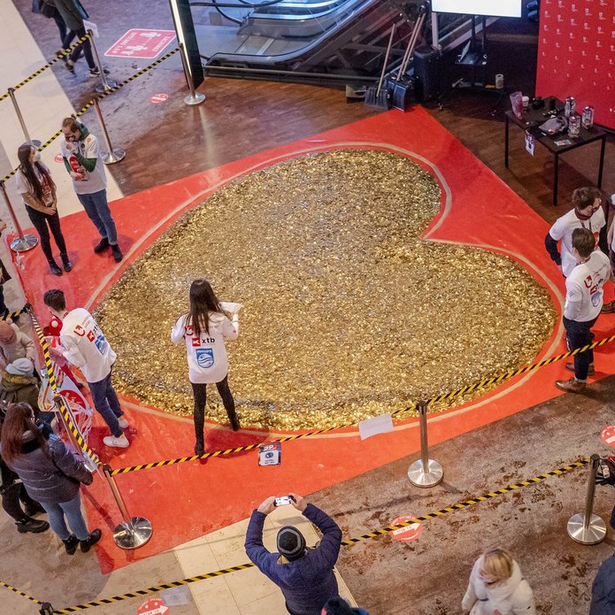 Students from the Student Science Club Inwestor with the UL Authorities are standing next to a heart made of gold coins