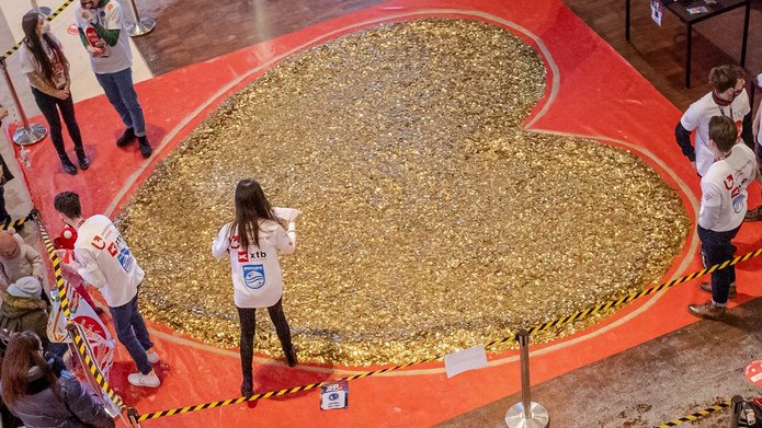 Studenci SKN Inwestor wraz z Władzami UŁ stoją przy sercu ułożonym ze złotych monet