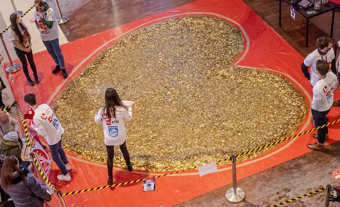 Studenci SKN Inwestor wraz z Władzami UŁ stoją przy sercu ułożonym ze złotych monet