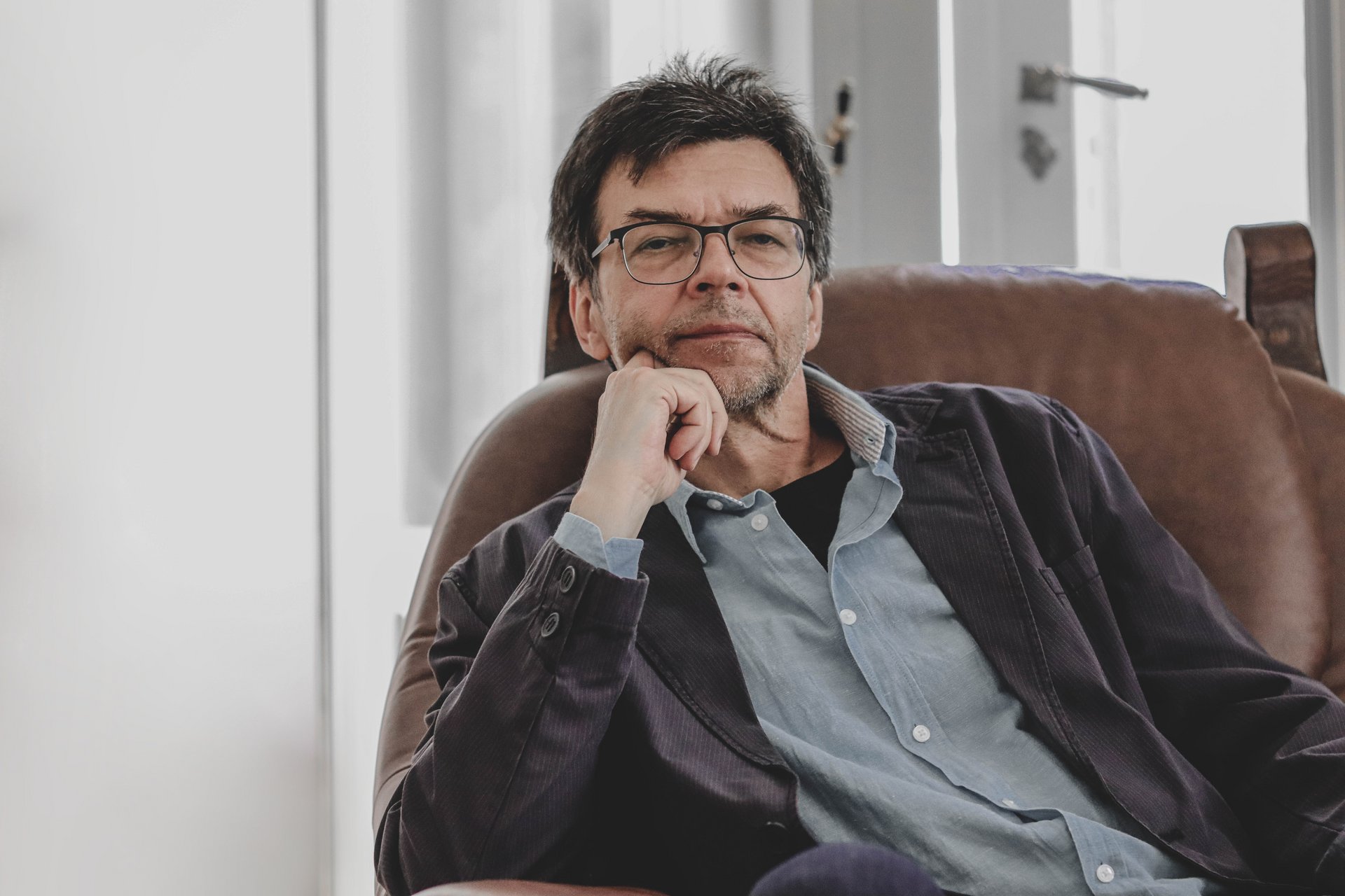 Maciej Świerkocki sitting on an armchair posing for a photo. 