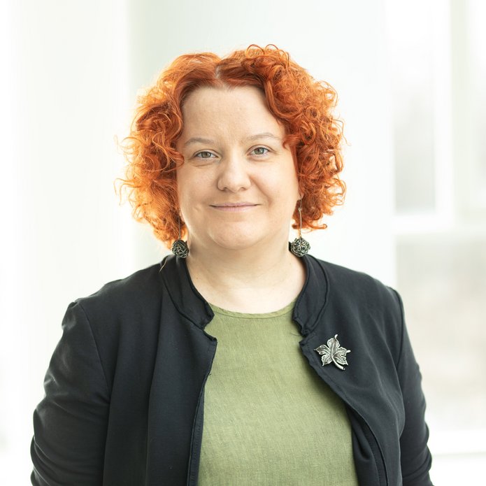 a portrait photo of Dr Kostrzyńska wearing a green blouse and a jacket