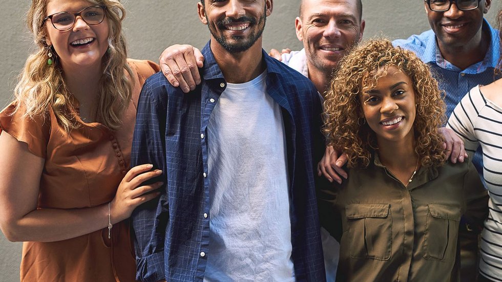 Shot of a group of cheerful friends standing together for a portrait while looking at the camera