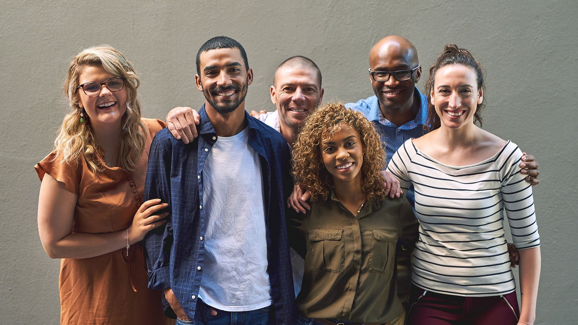 Shot of a group of cheerful friends standing together for a portrait while looking at the camera