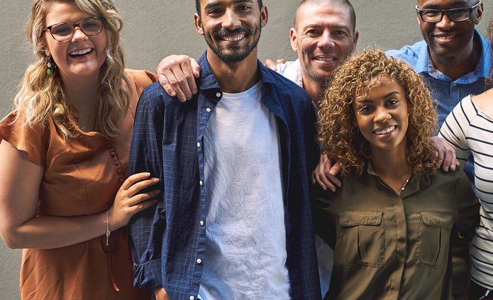 Shot of a group of cheerful friends standing together for a portrait while looking at the camera
