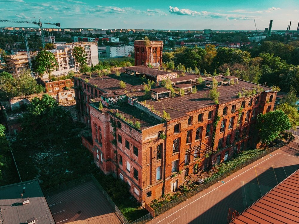 The ruins of a former textile factory surrounded by the construction of new residential buildings