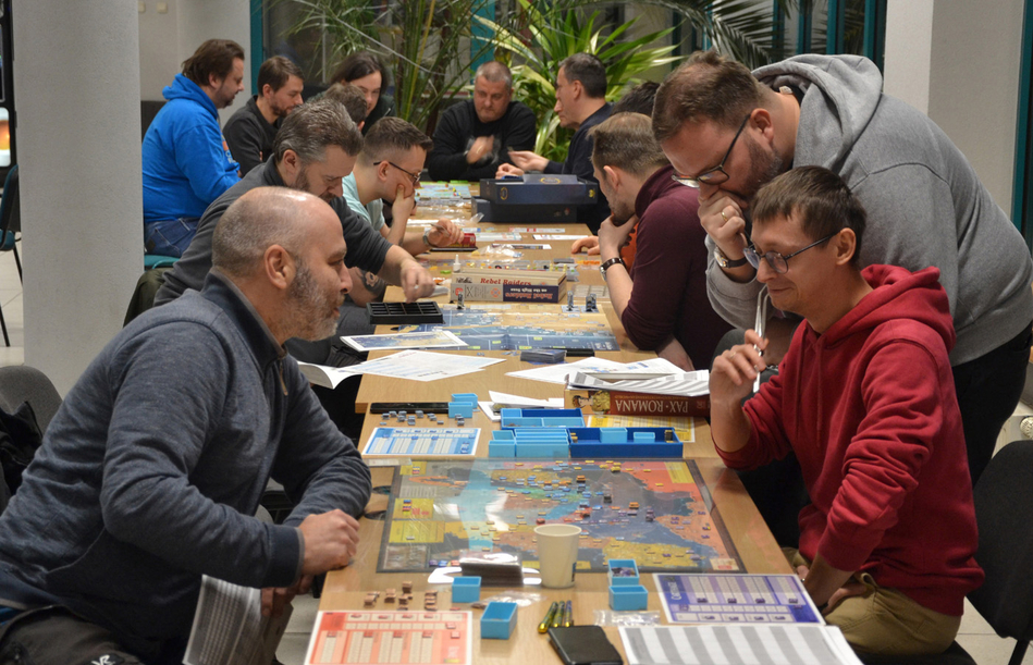 osoby uczestniczące w grze siedzące wokół stołu z grą osoby uczestniczące w grze siedzące wokół stołu z grą